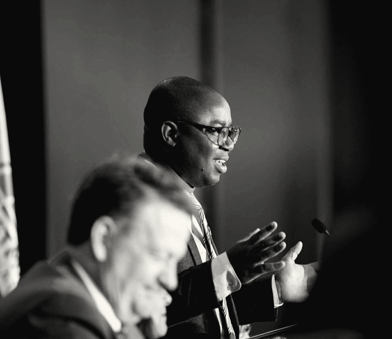 Frank Tsuro making a point across the table at a meeting.